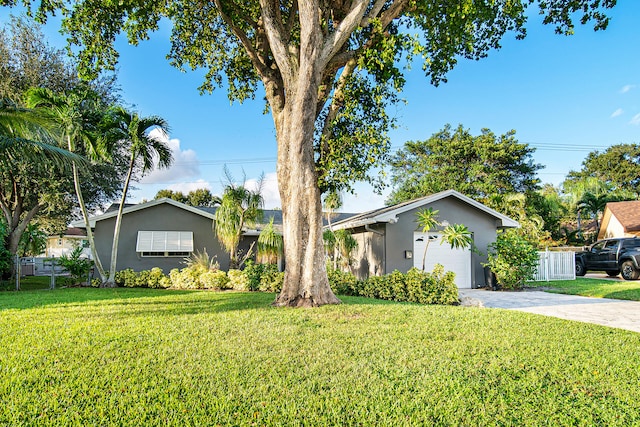 ranch-style home featuring a garage and a front lawn