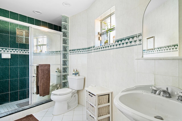 bathroom featuring toilet, an enclosed shower, and tile walls