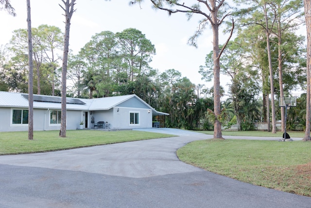 view of front of house featuring solar panels and a front lawn