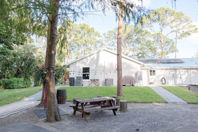 view of front facade with a front yard and central AC unit