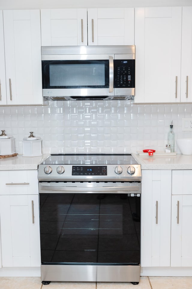 kitchen featuring white cabinets, stainless steel appliances, and backsplash