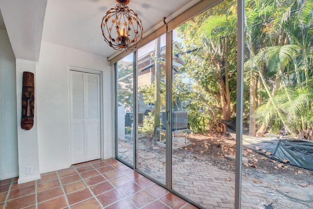 entryway featuring an inviting chandelier and tile patterned flooring