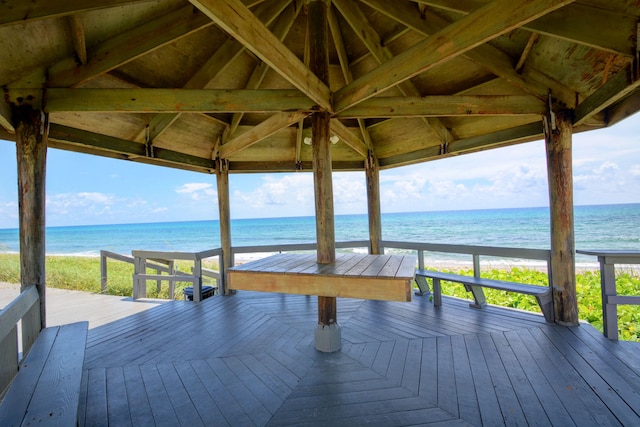 wooden terrace with a view of the beach and a water view