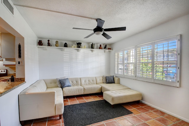 tiled living room with ceiling fan and a textured ceiling