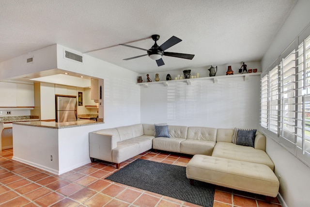 tiled living room with a textured ceiling and ceiling fan