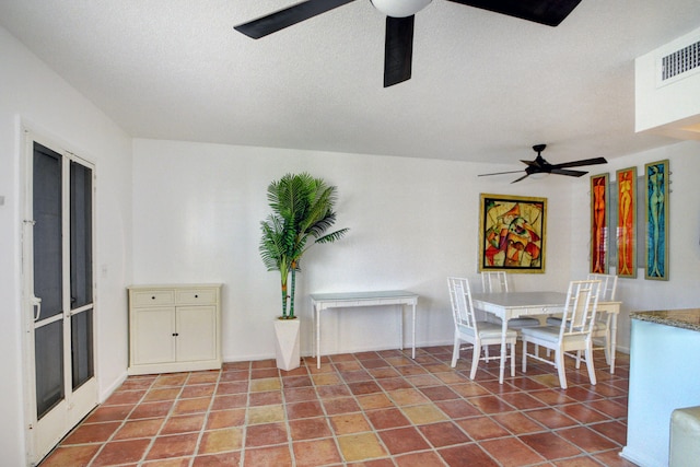 unfurnished dining area featuring a textured ceiling, tile patterned flooring, and ceiling fan