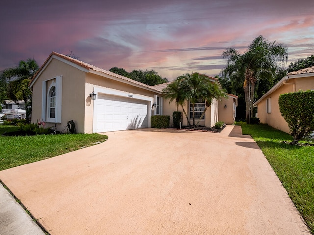 view of front of house with a garage and a lawn