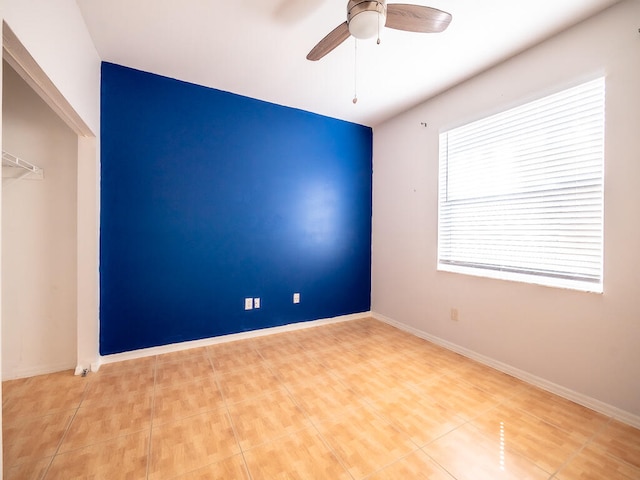 tiled empty room featuring ceiling fan