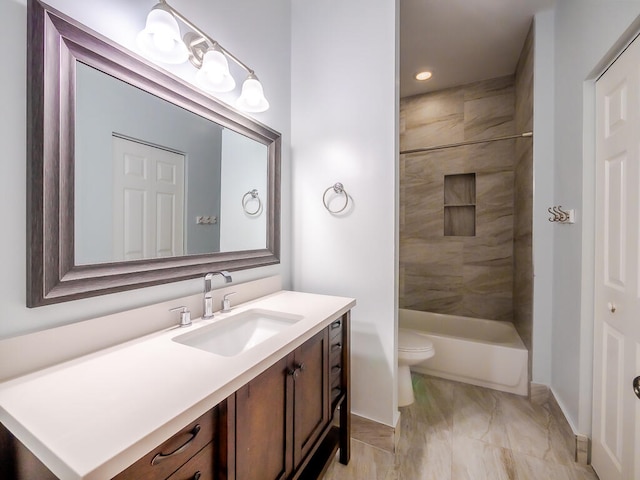 full bathroom featuring vanity, tiled shower / bath combo, and toilet