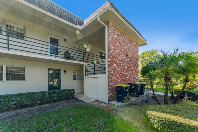 doorway to property with a yard and a balcony