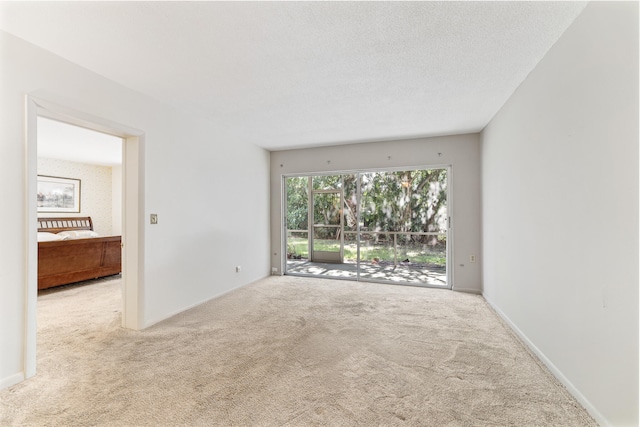 carpeted spare room with a textured ceiling