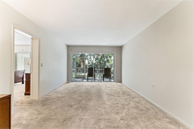 carpeted spare room featuring a textured ceiling