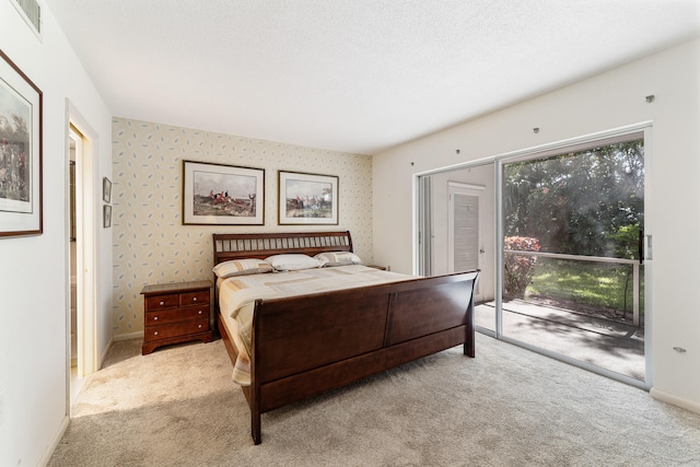 carpeted bedroom featuring access to outside and a textured ceiling