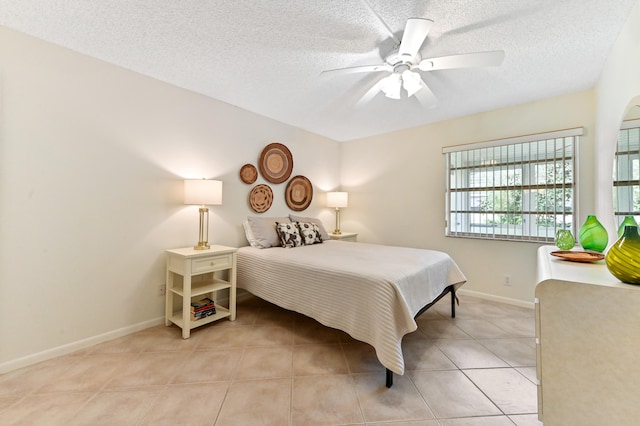 bedroom featuring a textured ceiling, light tile patterned floors, and ceiling fan