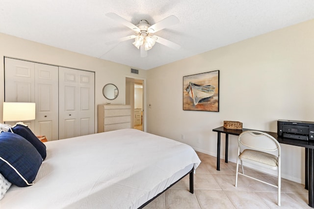 bedroom with a closet, ceiling fan, a textured ceiling, and light tile patterned floors