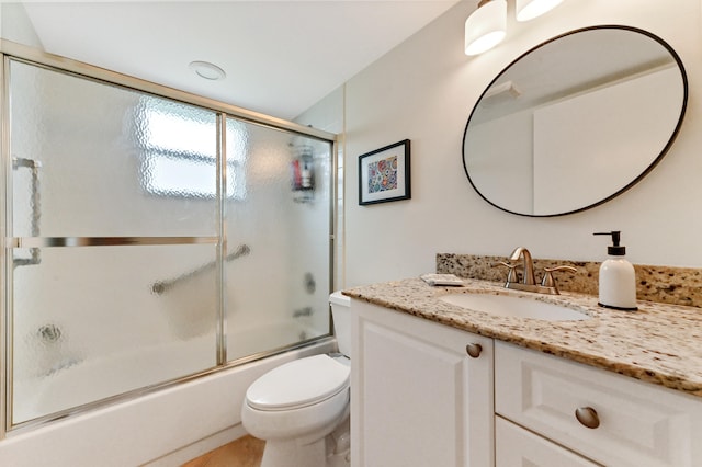 full bathroom featuring vanity, enclosed tub / shower combo, and toilet