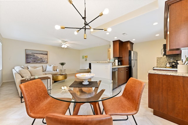 tiled dining area featuring ceiling fan with notable chandelier