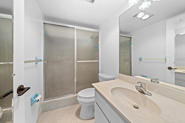 bathroom featuring toilet, an enclosed shower, vanity, and tile patterned floors