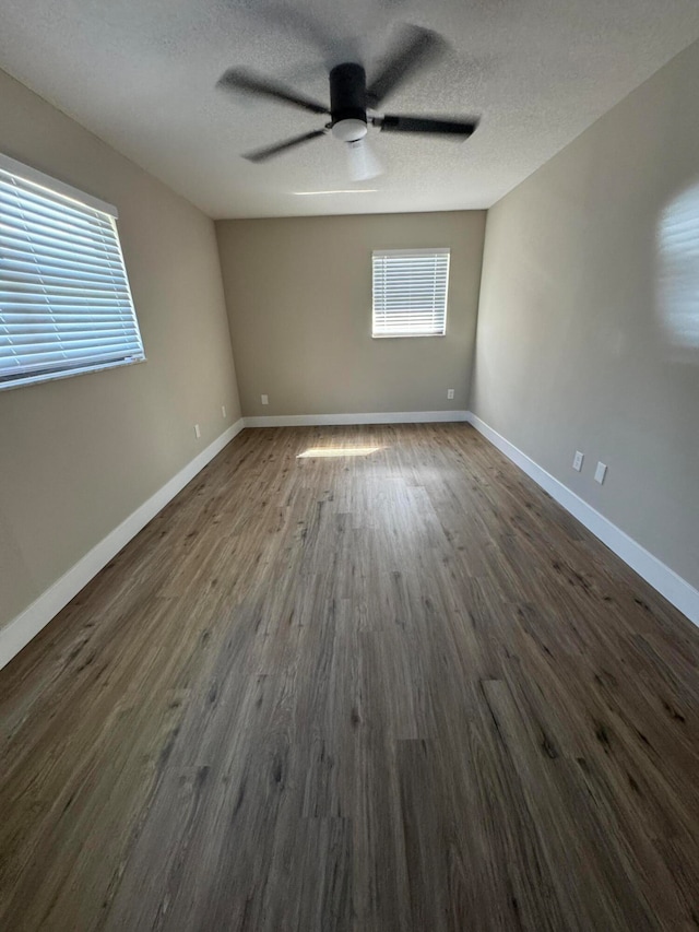 unfurnished room featuring dark wood-type flooring, a textured ceiling, and ceiling fan