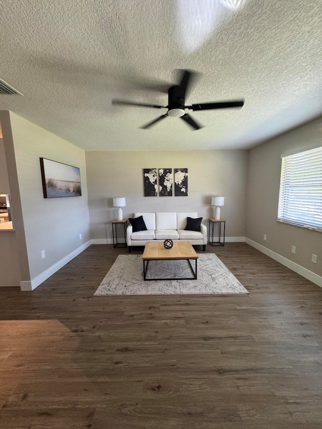 living room with a textured ceiling, dark hardwood / wood-style floors, and ceiling fan