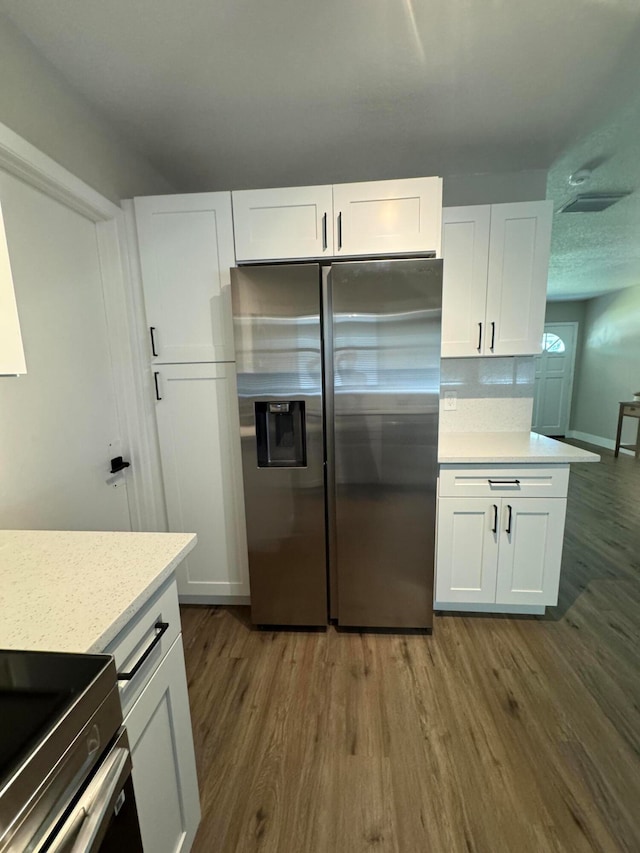 kitchen featuring white cabinets, dark hardwood / wood-style floors, and stainless steel fridge