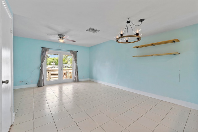 tiled empty room featuring ceiling fan with notable chandelier