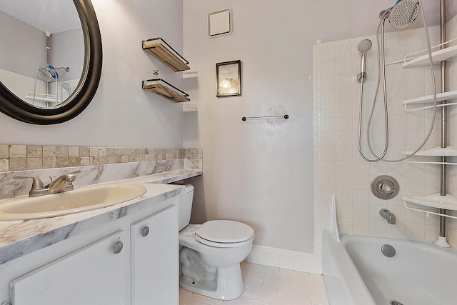 full bathroom with vanity, tiled shower / bath combo, toilet, and tile patterned flooring