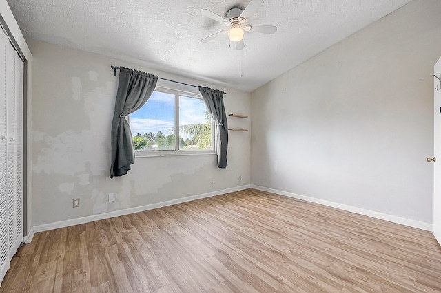 empty room with ceiling fan, a textured ceiling, and light hardwood / wood-style flooring