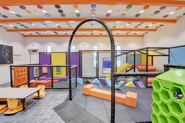 game room with beamed ceiling and plenty of natural light