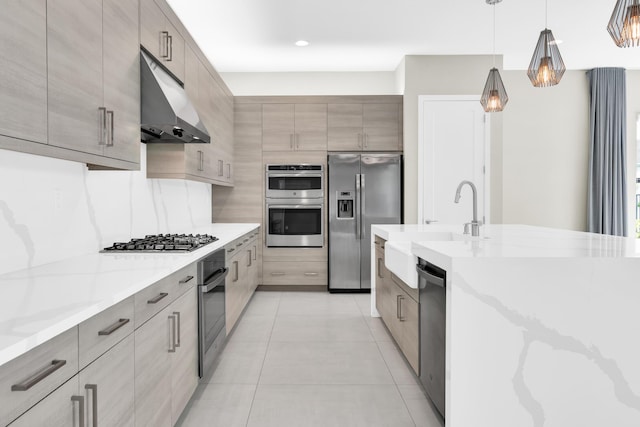 kitchen with pendant lighting, stainless steel appliances, light stone counters, and light tile patterned flooring