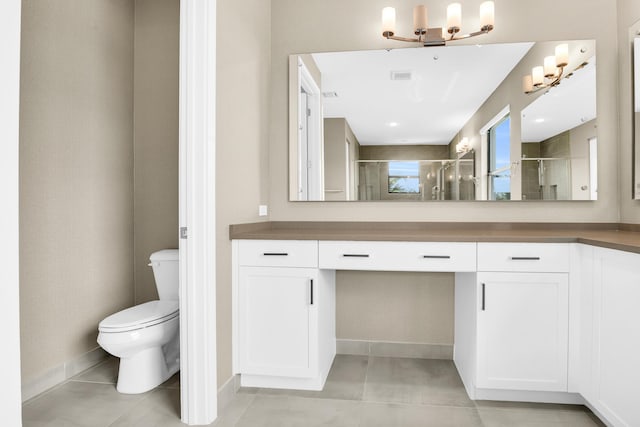 bathroom featuring tile patterned floors, vanity, toilet, and walk in shower