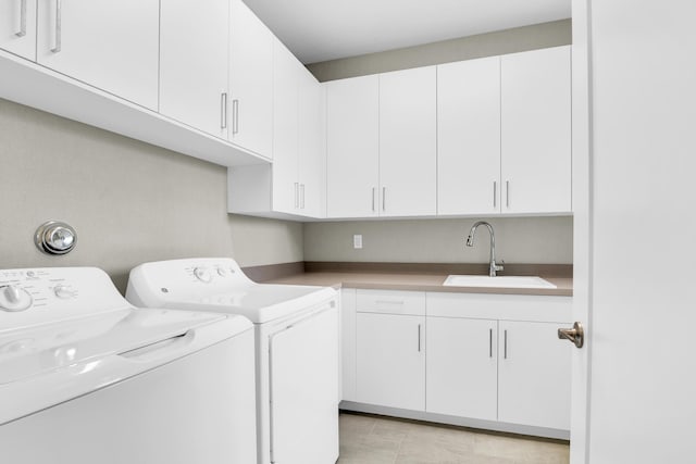 washroom featuring cabinets, separate washer and dryer, sink, and light tile patterned floors