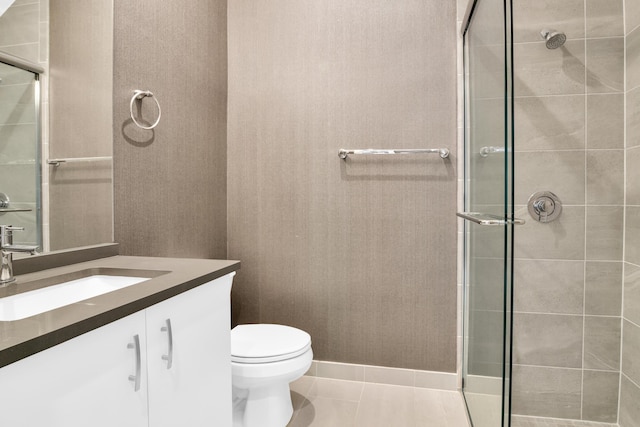 bathroom featuring tile patterned flooring, vanity, a shower with door, and toilet