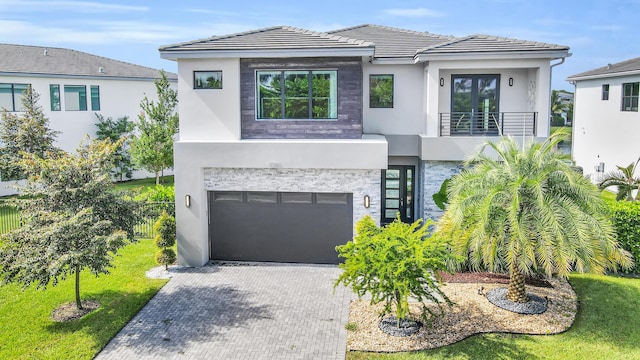 view of front of home featuring a garage and a balcony