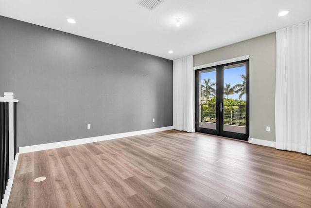 unfurnished room with french doors and light hardwood / wood-style flooring