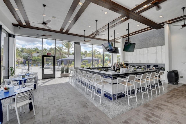 kitchen with white cabinetry, ceiling fan, hanging light fixtures, a kitchen breakfast bar, and a spacious island