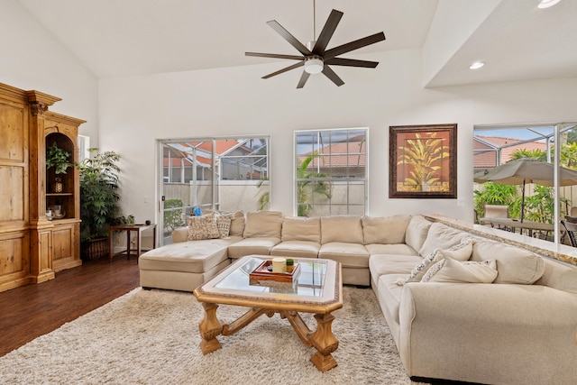 living room featuring a wealth of natural light, ceiling fan, high vaulted ceiling, and dark hardwood / wood-style flooring