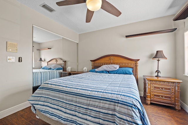 bedroom with dark hardwood / wood-style floors, a textured ceiling, and ceiling fan