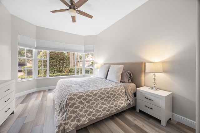 bedroom featuring baseboards, multiple windows, and light wood-style floors