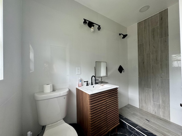 bathroom featuring vanity, toilet, and a shower