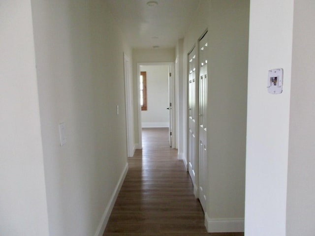 hallway with dark hardwood / wood-style flooring