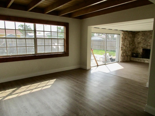 unfurnished room with hardwood / wood-style flooring, a fireplace, beam ceiling, and wood ceiling