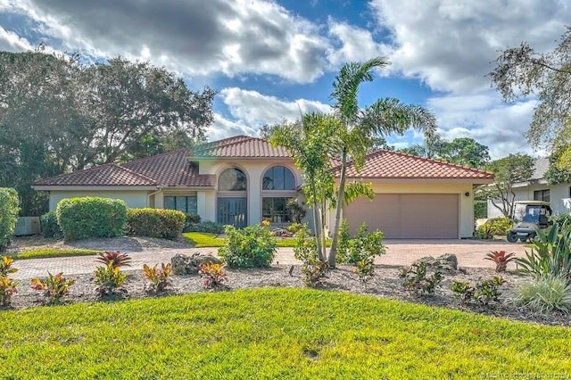 mediterranean / spanish-style house featuring a garage and a front yard