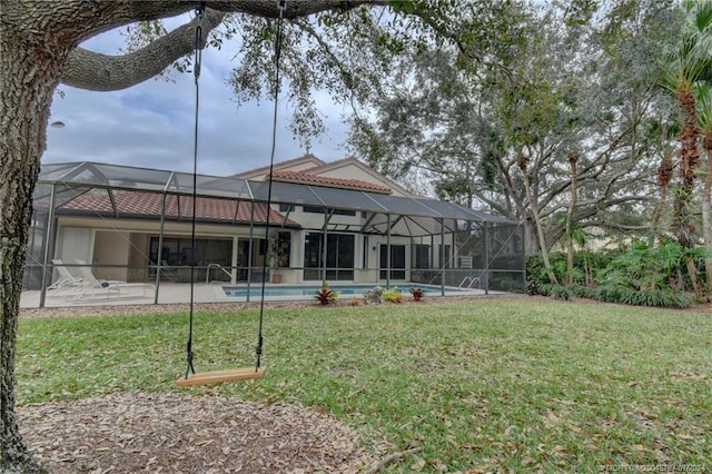 rear view of house with a patio, a lanai, and a yard