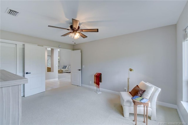 living area with ceiling fan and light carpet