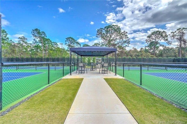 view of sport court with a yard and a water view