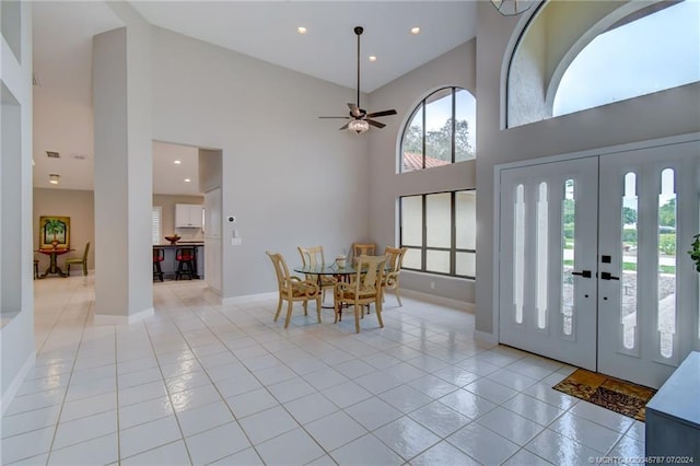 tiled entrance foyer with french doors, ceiling fan, and a high ceiling