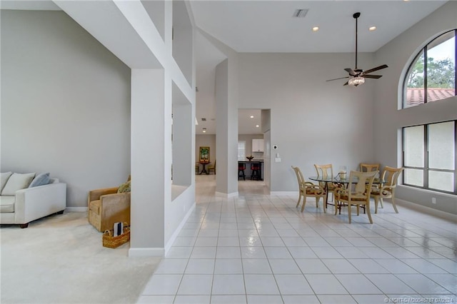 dining area with light tile patterned flooring, a high ceiling, and ceiling fan