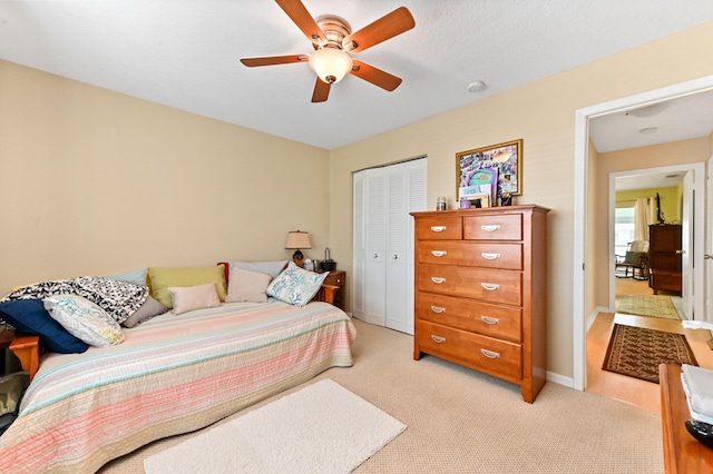 bedroom with light carpet, a closet, and ceiling fan