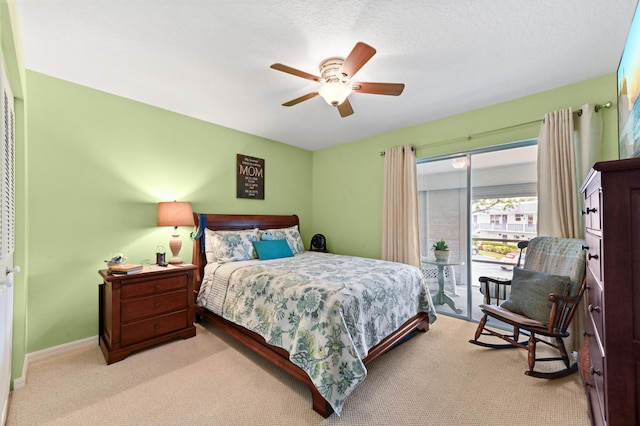 carpeted bedroom with ceiling fan, access to outside, and a textured ceiling